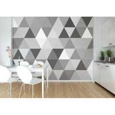 a kitchen with a white table and chairs next to a wall covered in grey triangles