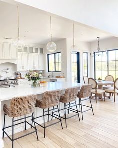 a kitchen filled with lots of counter top space and chairs next to an island in the middle