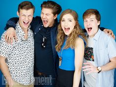 four people posing for the camera with their arms around each other and one person making a funny face