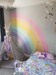 a child's bedroom with a teepee tent and rainbow wallpaper on the walls