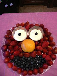 a plate with strawberries and berries in the shape of an angry bird