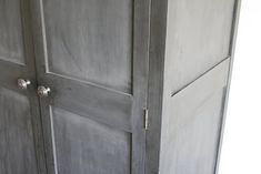 an old gray cupboard with two doors and knobs