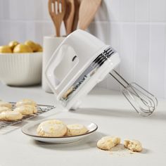 a white mixer and some cookies on a table