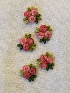 small pink flowers on white fabric with green leaves and stems in the center, set of four