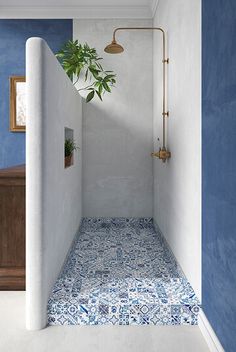 a blue and white bathroom with a plant in the corner