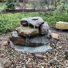 a rock fountain with water running down it