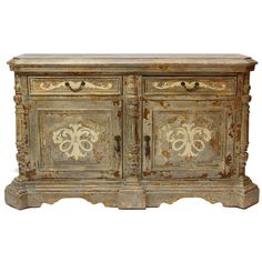 an old wooden cabinet with ornate carvings on the doors and drawers, painted in gold