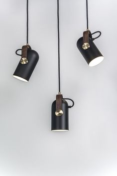 three black and gold lights hanging from the ceiling