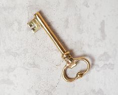 an antique brass key on a white marble counter top with the handle still attached to it