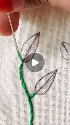 someone is stitching leaves with green thread