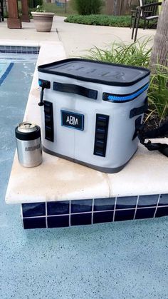 a cooler sitting on the edge of a swimming pool