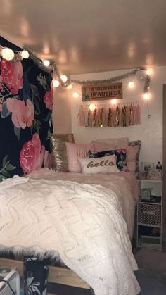 a bed with pink flowers and lights on the headboard