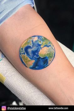 the earth tattoo is on someone's arm