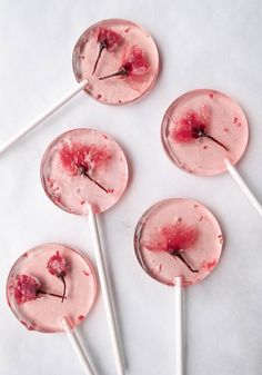 four lollipops with blood on them sitting on top of a white table