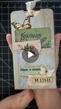 someone is holding up an old book with butterflies on it