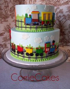 a three layer cake decorated with trains and clouds