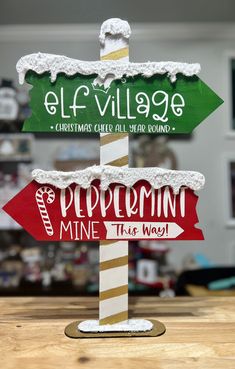 a wooden sign sitting on top of a table in front of a wall with christmas decorations