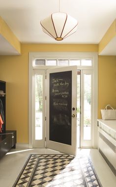 a black and white checkered floor in front of a door with chalk written on it