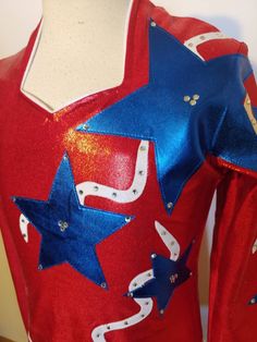 "Here is a showstopping Patriotic shirt that will show your Patriotism to the Red, White and Blue! Shirt base is red shiny dot lycra for stretch and comfort. Accented in Blue metallic stars and White Rays. Dotted with Clear Swarovski rhinestones. Zip back and attached brief with velcro closure. Merchandise is shipped within 2 to 3 weeks. If a rush order is needed, call us at 435.257.2286 , message us here, or e-mail us at gloria [!at] rodeoqueenshirts.com to check availability. We try to keep 1 Red White And Blue Shirt, Queen Shirt, Rodeo Shirts, Rodeo Queen, Queen Shirts, Patriotic Shirt, Patriotic Shirts, Under The Lights, Western Shirts