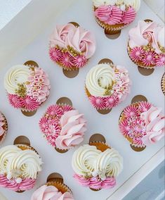 cupcakes with pink and white frosting in a box