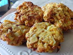 four muffins on a white plate sitting on a table