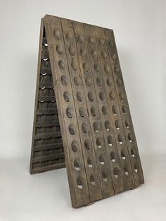 a wooden rack with holes in it on a white background and an upside down shelf