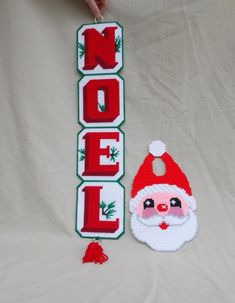 a santa clause ornament next to a handmade christmas sign that says noel