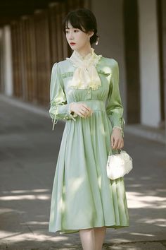 Radiate an air of sophistication in this dress that takes inspiration from the Edwardian period. It features a high collar neckline with delicate floral embroidery, lace frills and attached neck-piece. For added elegance, the shoulder seams are slightly puffed, and waistline sits on the upper-waist. Sleeves are cuffed with lace and three button closures, plus a ribbon detail. The dress has a buttoned front closure and concealed side zipper for ease of wear. It is made with a silky satin fabric a