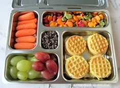 a lunch box filled with fruit, waffles and veggies on the side