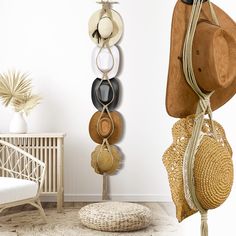 several hats hanging from hooks on the wall next to a wicker chair and ottoman