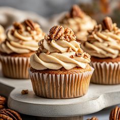 several cupcakes with frosting and pecans on top