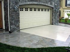 a house with stone walls and two garage doors