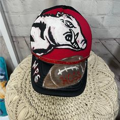 a baseball cap with a bear on it sitting on top of a round table next to a brick wall