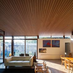 a living room filled with furniture next to a dining room table and window covered in wooden slats