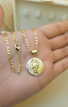 Beautiful Gift!  St Jude Pendant, Figaro Chain Necklace. ✅️ 18k Gold Filled  ✅️ Nickel free and hypoallergenic Necklace length option:  - 22inch, 3mm wide Jewelry Care:   - Do not use while sleeping, exercising,  and showering. - Make sure perfume, lotions, hair products are dry before putting jewelry on. - Only use a clean cloth with gentle motions. --------------------------------- Muy bonita Cadena! Cadena de San Juditas Tadeo  ✅️ Oro Laminado 18k ✅️ Níquel libre e Hipoalergénico Largo de Cadena Opciones: - 22 pulgadas, 3mm ancho  Cuidado de la joyería: - No usar a la hora de dormir, hacer ejercicio, y bañar. - Aplique joyas después de dejar secar su perfume, productos de cabello, y cremas. - Solo limpie sus joyas con un paño limpio y seco. Figaro Chain Jewelry With Round Pendant As Gift, Gift Necklaces With Figaro Chain, Hypoallergenic Necklace, Figaro Chain Necklace, St Jude, Figaro Chain, Necklace Length, Hair Products, Cute Jewelry