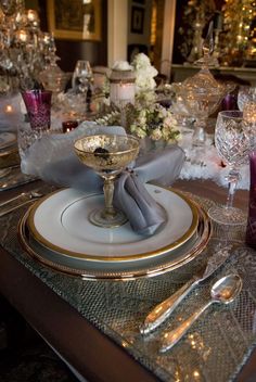 the table is set with silver and gold dishes