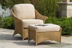 a wicker chair and ottoman sitting on a patio