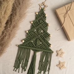 a green christmas tree ornament next to a present box and twinklings