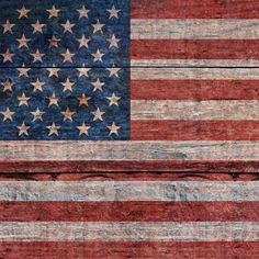 an american flag painted on the side of a wooden wall with peeling paint and faded edges