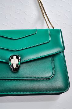 Marked by an urban lifestyle and a trendy wearability, the new “Serpenti Forever” crossbody bag brings a cool touch to the Serpenti universe. Crafted in emerald green calf leather, this model features light gold-plated brass hardware. The iconic snake head closure hypnotizes with black and white agate enamel and seductive eyes in green malachite. Perfect to accessorize a fashionable daywear look, the bag features a sinuous and adjustable snake body-shaped chain with a leather strap. Bvlgari Fragrance, Seductive Eyes, Snake Head, Fragrance Samples, Model Features, Group Gifts, Green Malachite, Urban Lifestyle, White Agate