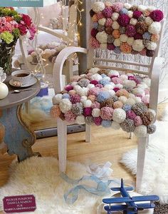 a chair with pom - poms on the back and seat is featured in this magazine