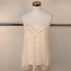 This Pretty Camisole Tank To Top Features Lace Detailing On The Front And Back. Tie Front With Tassels And Spaghetti Straps. White Beach Camisole With Built-in Bra, Feminine Tops With Adjustable Straps For Vacation, Beach Camisole With Straps, White Tank Camisole With Delicate Straps, White Adjustable Straps Camisole For Day Out, White Camisole With Adjustable Straps For Day Out, White Sleeveless Camisole With Delicate Straps, White Camisole Top With Delicate Straps, Sleeveless Tops With Delicate Straps For Vacation