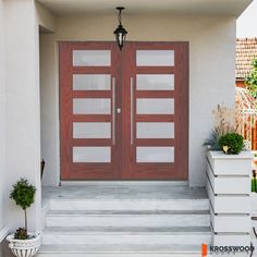 the front door to a house with steps and potted plants