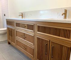 a bathroom with wooden cabinets and a white toilet