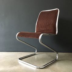 a chair that is sitting on top of a floor in front of a gray wall