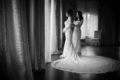 two women standing next to each other in front of curtains