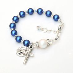 This beautiful rosary bracelet features glowing iridescent dark blue and white Swarovski crystal pearls and sparkly clear Swarovski crystals. All of the pearls and crystals are genuine Swarovski crystal. ✻ 6mm iridescent dark blue pearls represent the Hail Mary prayers. ✻ 8mm iridescent Swarovski white pearl represent the Our Father prayer; accented by clear crystal rhinestones on each side. ✻ Pearls are separated by smaller Swarovski diamond-shaped crystals in a sparkly finish. I hand-wrap a sp Blue Spiritual Jewelry For First Communion, Adjustable Beaded Blue Rosary Bracelet, Elegant Adjustable Blue Rosary Bracelet, Blue Rosary Bracelet Gift, Blue Cross Rosary For Gift, Blue Spiritual Rosary With Gemstone Beads, Baby Girl Baptism, Rosary Bracelet, Baptism Girl