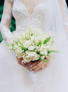 a bride holding a bouquet of white flowers