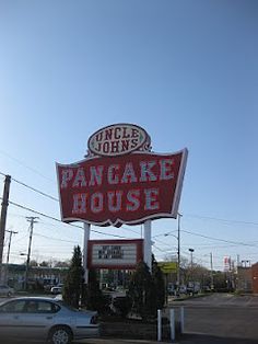 a pancake house sign with a car parked in front