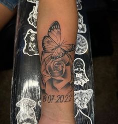 a woman's arm with a butterfly and rose tattoo on it